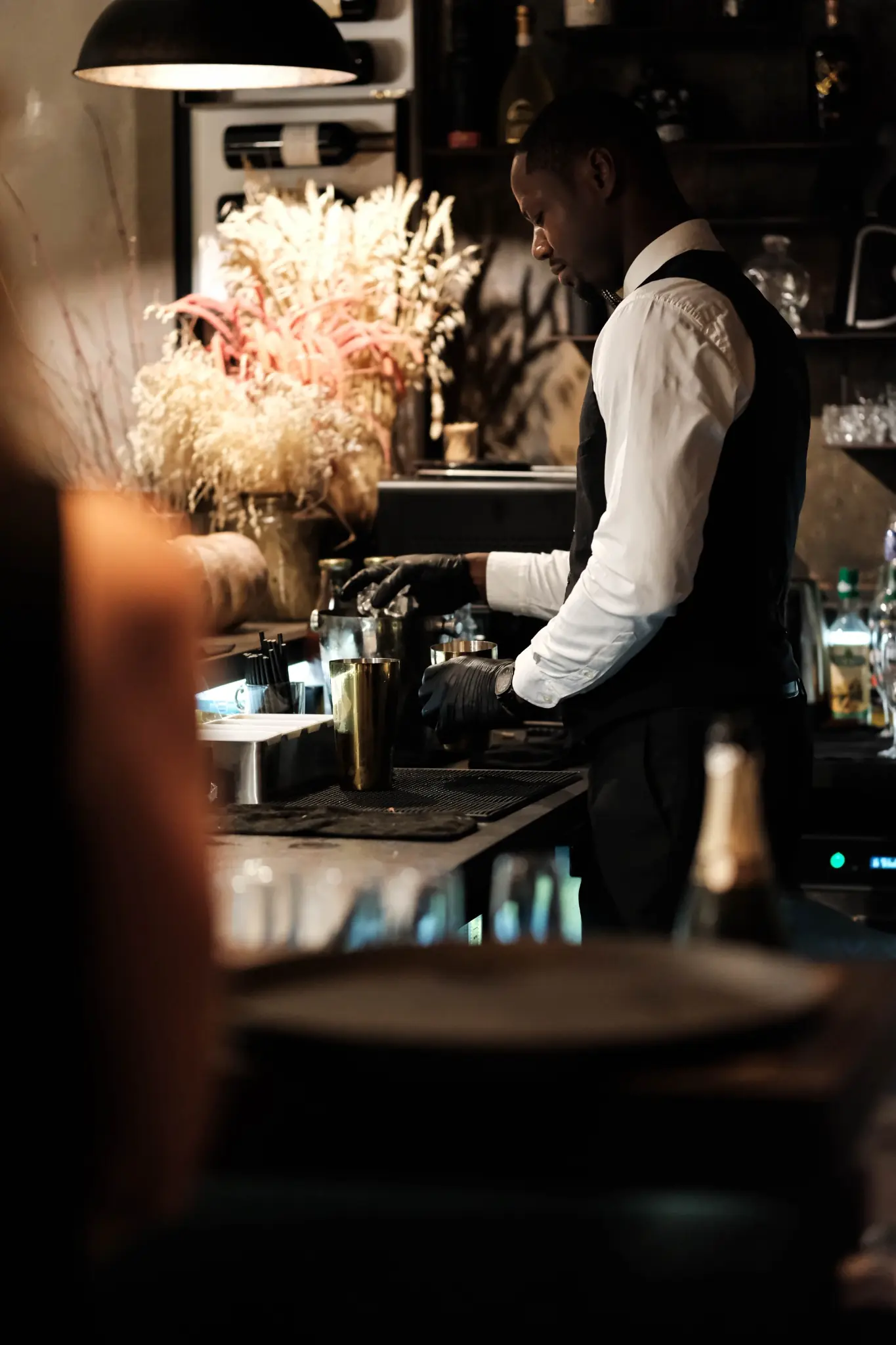 Bernis Bakala préparant un cocktail derrière le bar